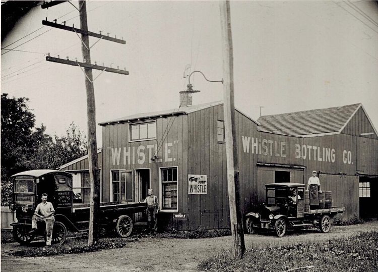 vintage Whistle Bottling Co photo of plant with trucks and men