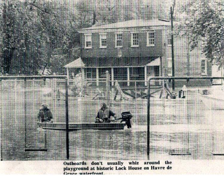 Another view of the Lock House following major flooding - boat motoring down what would be "Water Street"