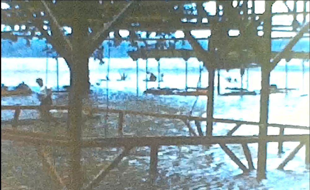 What appears to be a carousel or amusement ride of small boats or cars in the water near the railroad bridge at Havre de Grace, MD following Hurricane Hazel in 1954.