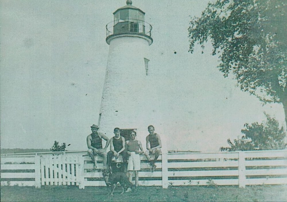 Image of Concord Point Lighthouse in Havre de Grace with young boys sitting on fence, thanks to Steve Lay sharing his father Ken's photos. late 1800s